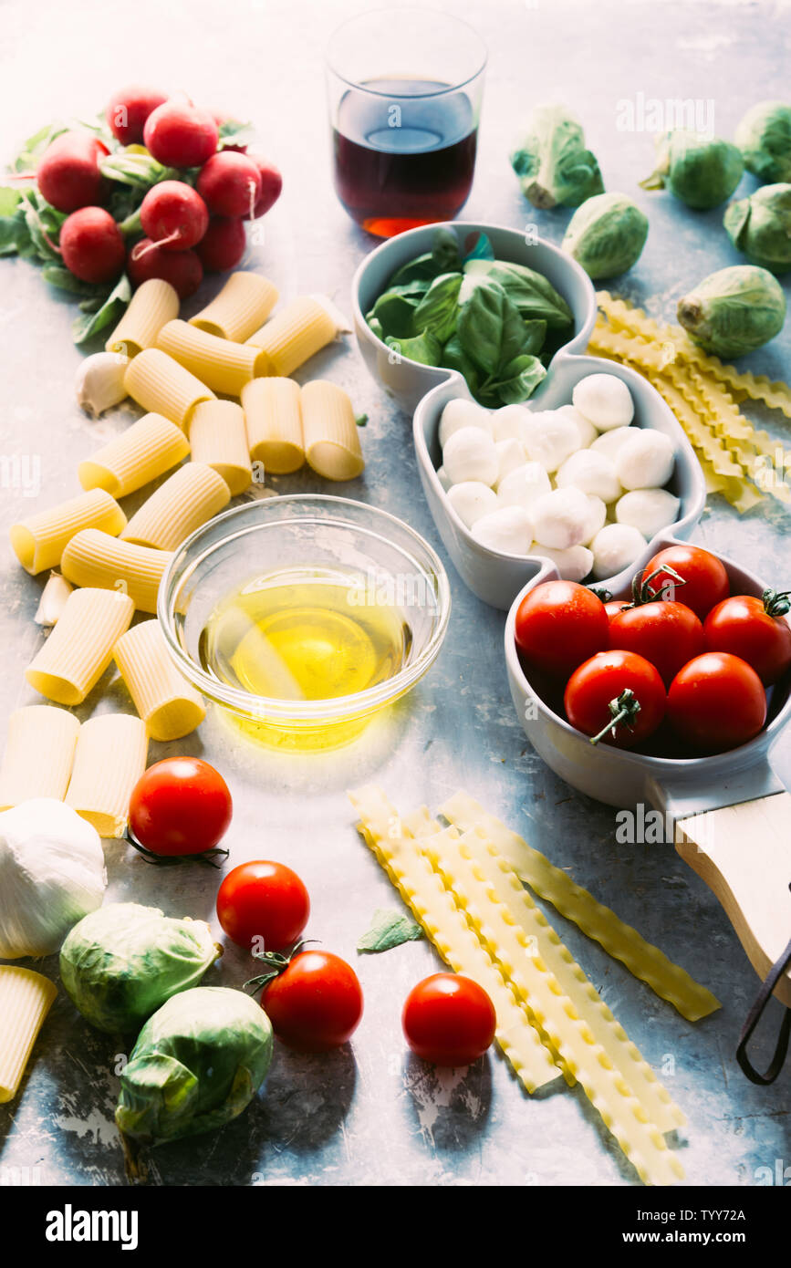 Pomodoro e Basilico mozzarella. Ingredienti alimentari pattern con mozzarella di sfere e di foglie di basilico fresco, round di pomodori ciliegini, con pasta e vino Foto Stock