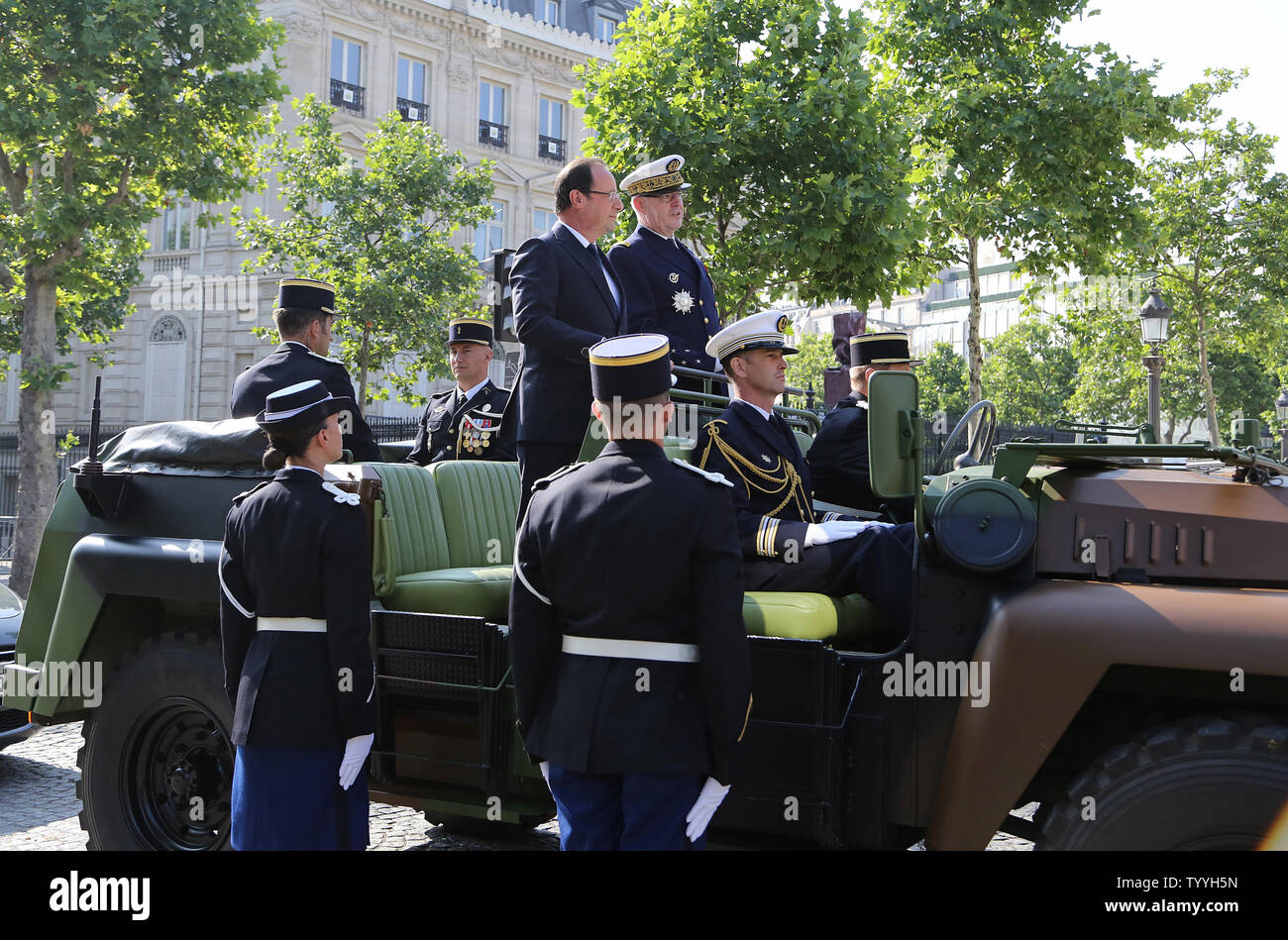 Il Presidente francese Francois Hollande (L) e la marina francese Ammiraglio Edouard Guillaud a bordo di una jeep militari prima dell' inizio della sessione annuale della commissione per il giorno della Bastiglia parata militare a Place Charles de Gaulle a Parigi il 14 luglio 2013. UPI/David Silpa Foto Stock