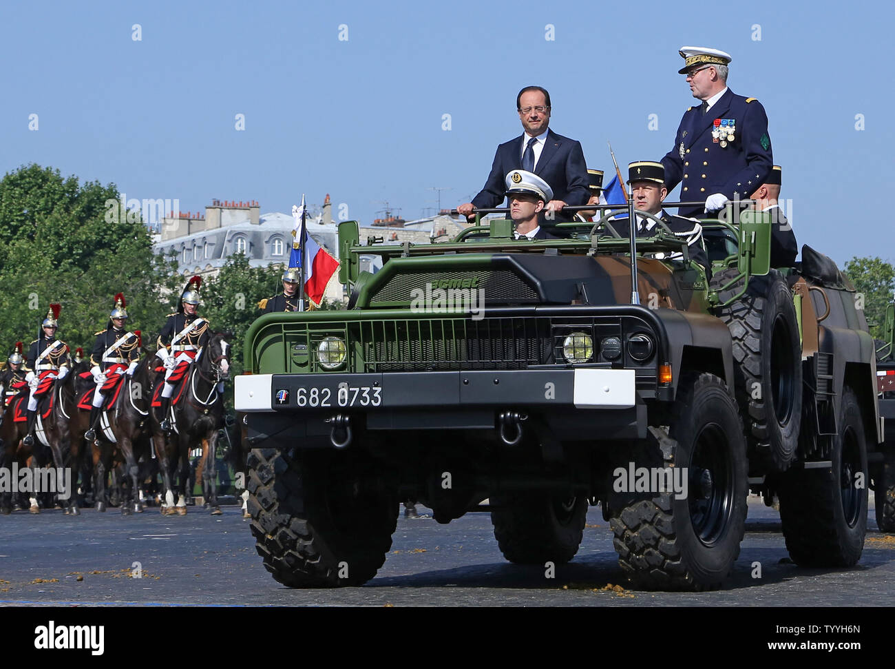 Il Presidente francese Francois Hollande (L) e la marina francese Ammiraglio Edouard Guillaud guidare attraverso la Place Charles de Gaulle in una jeep militari all'inizio della sessione annuale della commissione per il giorno della Bastiglia parata militare a Parigi il 14 luglio 2013. UPI/David Silpa Foto Stock