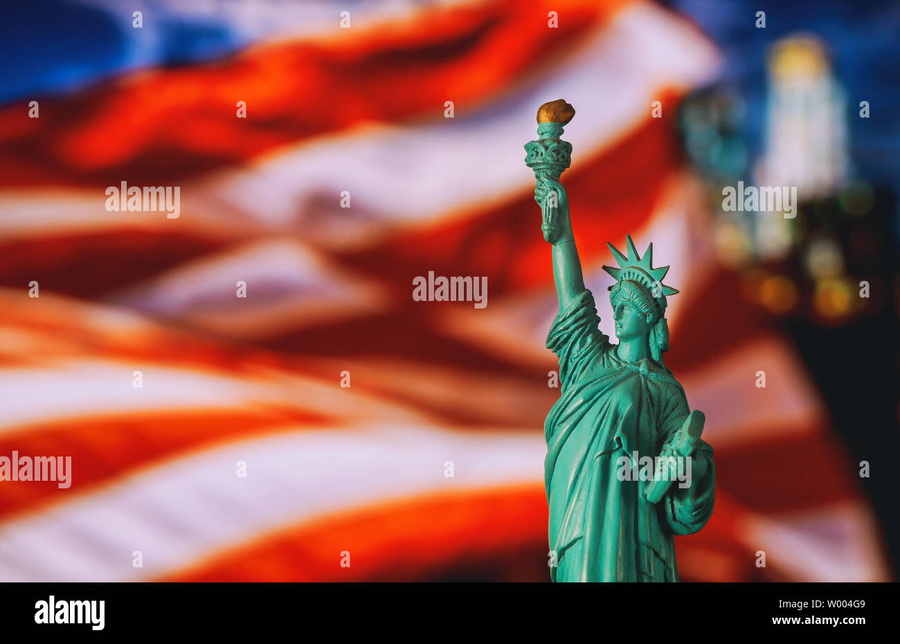 CLOSE UP della statua della libertà con la sfocatura bandiera americana nella città di New York Foto Stock