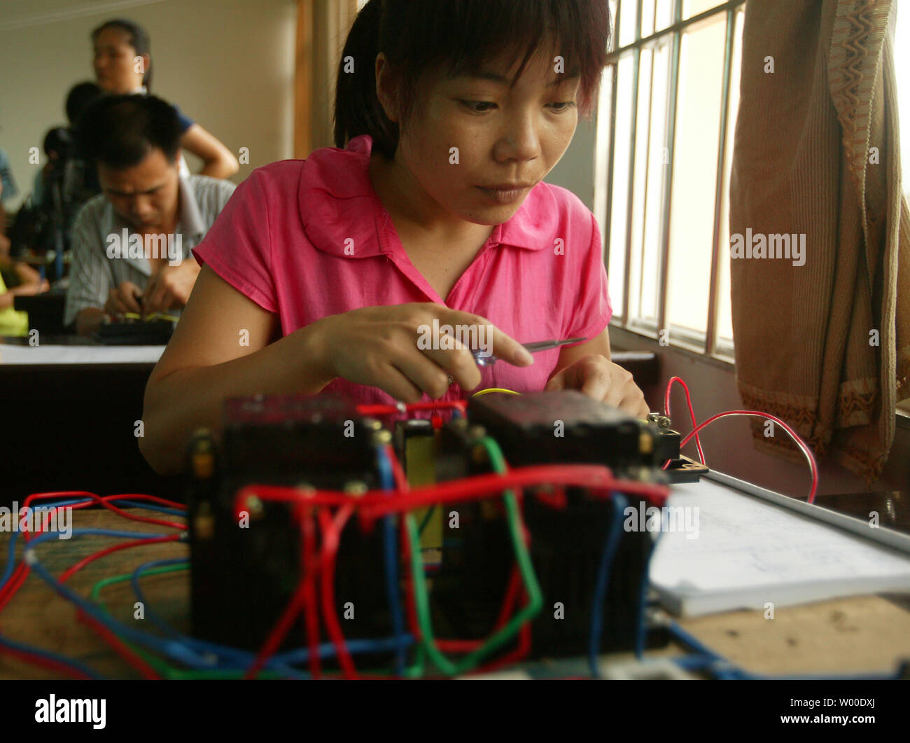 Disoccupati cinesi lavoratori migranti vengono riqualificati per nuove competenze professionali a un governo sponsorizzato trade school In Daxin, provincia di Guangxi, il 2 luglio 2009. Quasi venti milioni di fuori della Cina il totale stimato dei 130 milioni di lavoratori migranti, la cui manodopera a basso costo sottende la Cina del settore manifatturiero sono stati costretti a tornare in aree rurali a causa della mancanza di lavoro, secondo un sondaggio condotto dal Ministero dell'Agricoltura che è stato citato in un briefing. (UPI foto/Stephen rasoio) Foto Stock