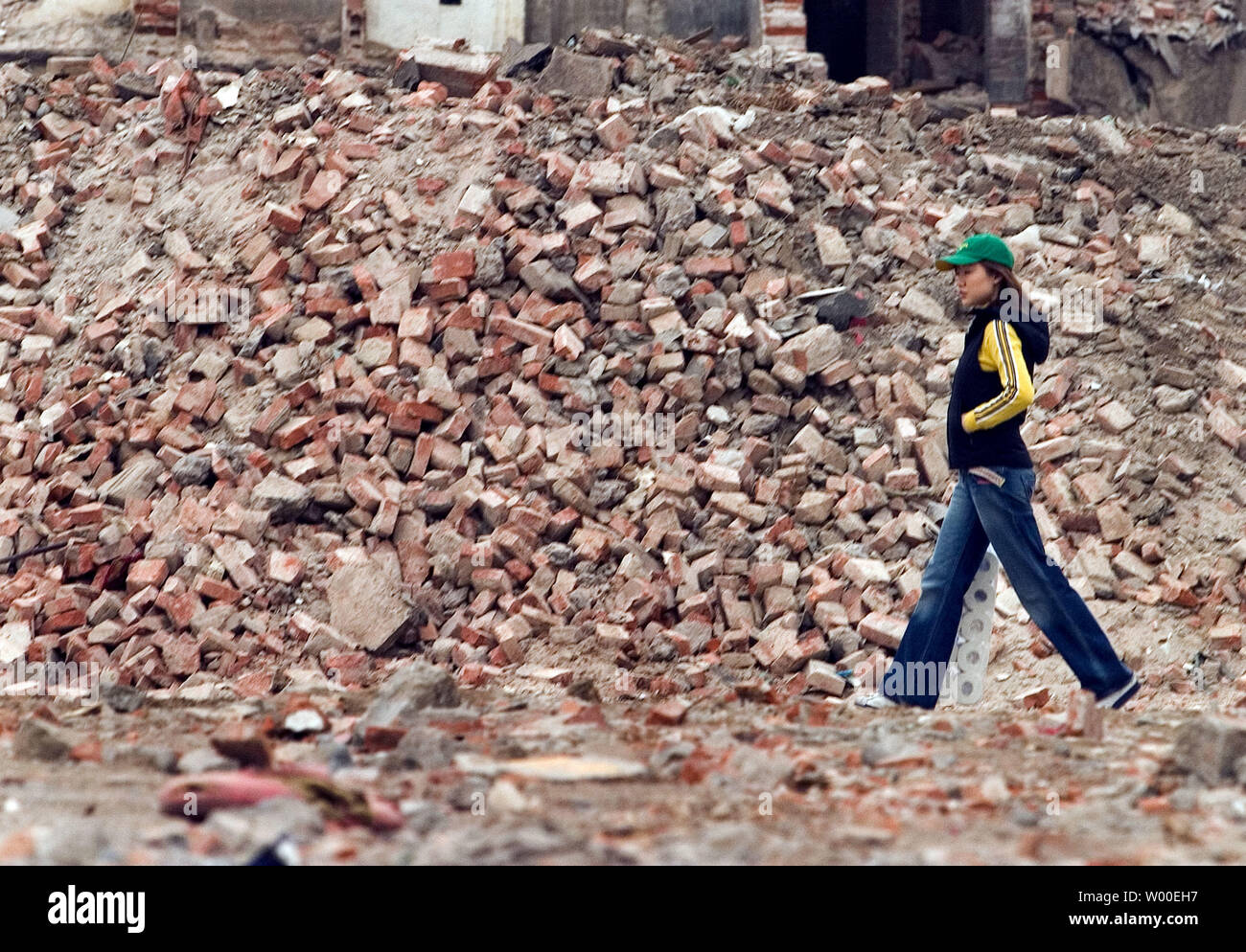 Una donna cinese passeggiate attraverso i detriti di una recente demolito quartiere rivestita con antichi vicoli, a Pechino il 5 maggio 2006. In tutta la Cina, milioni di agricoltori in migliaia di villaggi hanno incontrato simile parche, spinto in parte dalla necessità di terra per costruire le fabbriche, appartamenti, gli ospedali e le strade in un paese che gode di più del 9 per cento annuo di crescita. (UPI foto/Stephen rasoio) Foto Stock