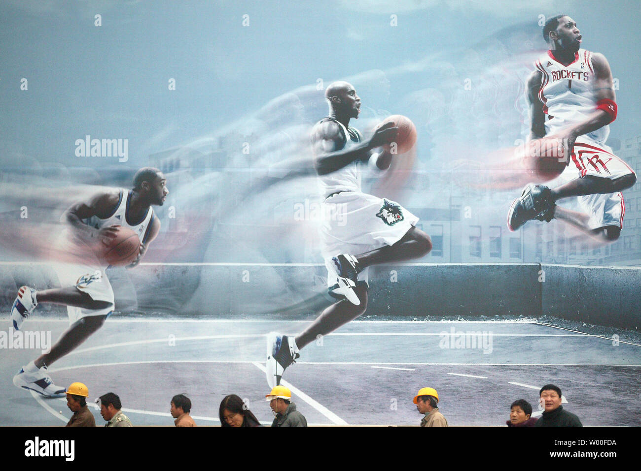 Costruzione cinese i lavoratori a piedi passato una massiccia pubblicità  Adidas con NBA superstars nel centro cittadino di Pechino in Cina il 11  dicembre 2006. Un rallentamento delle riforme in Cina potrebbe