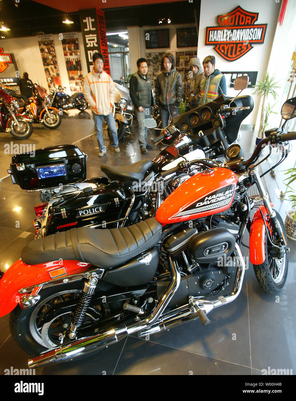 Giovani uomini cinesi check out la più recente linea di Harley-Davidson motociclette in vendita presso l'azienda showroom principale a Pechino in Cina il 25 dicembre 2007. Gli Stati Uniti riverbero pressione la scorsa settimana sulla Cina alla fine le barriere commerciali che hanno messo i freni su iconico americano-costruito Harley-Davidson motociclette in tutto il mondo più grande mercato. (UPI foto/Stephen rasoio). Foto Stock