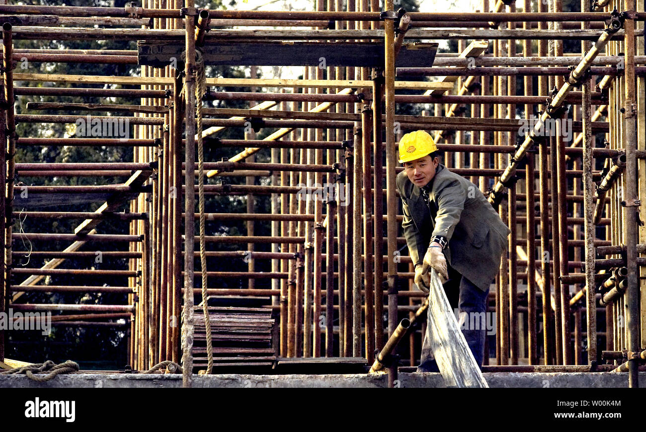 Un migrante lavoratore cinese funziona su un nuovo complesso commerciale in costruzione a Pechino il distretto commerciale Dicembre 9, 2008. La Banca mondiale la scorsa settimana tagliato la sua previsione per ChinaÕs espansione economica del prossimo anno al 7,5 per cento, il più basso in quasi due decenni, citando ridotto la domanda d'oltremare. La Cina è stata in media del 9,9 per cento di crescita annuale per gli ultimi trent'anni. (UPI foto/Stephen rasoio) Foto Stock