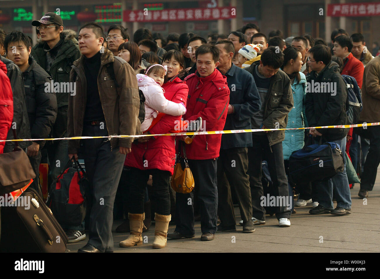 Nuovo anno lunare cinese i viaggiatori stand in linea presso uno di Pechino la stazioni ferroviarie principali Febbraio 04, 2009. Vicino a venti milioni di della Cina di lavoratori migranti sono tornati a casa dopo aver perso i loro posti di lavoro, con oltre la metà di ritornare disoccupati dalla città alla campagna. Il primo documento del governo di quest'anno ha avvertito 2009 sarà "eventualmente l'anno più difficili' dall'anno 2000. (UPI foto/Stephen rasoio) Foto Stock