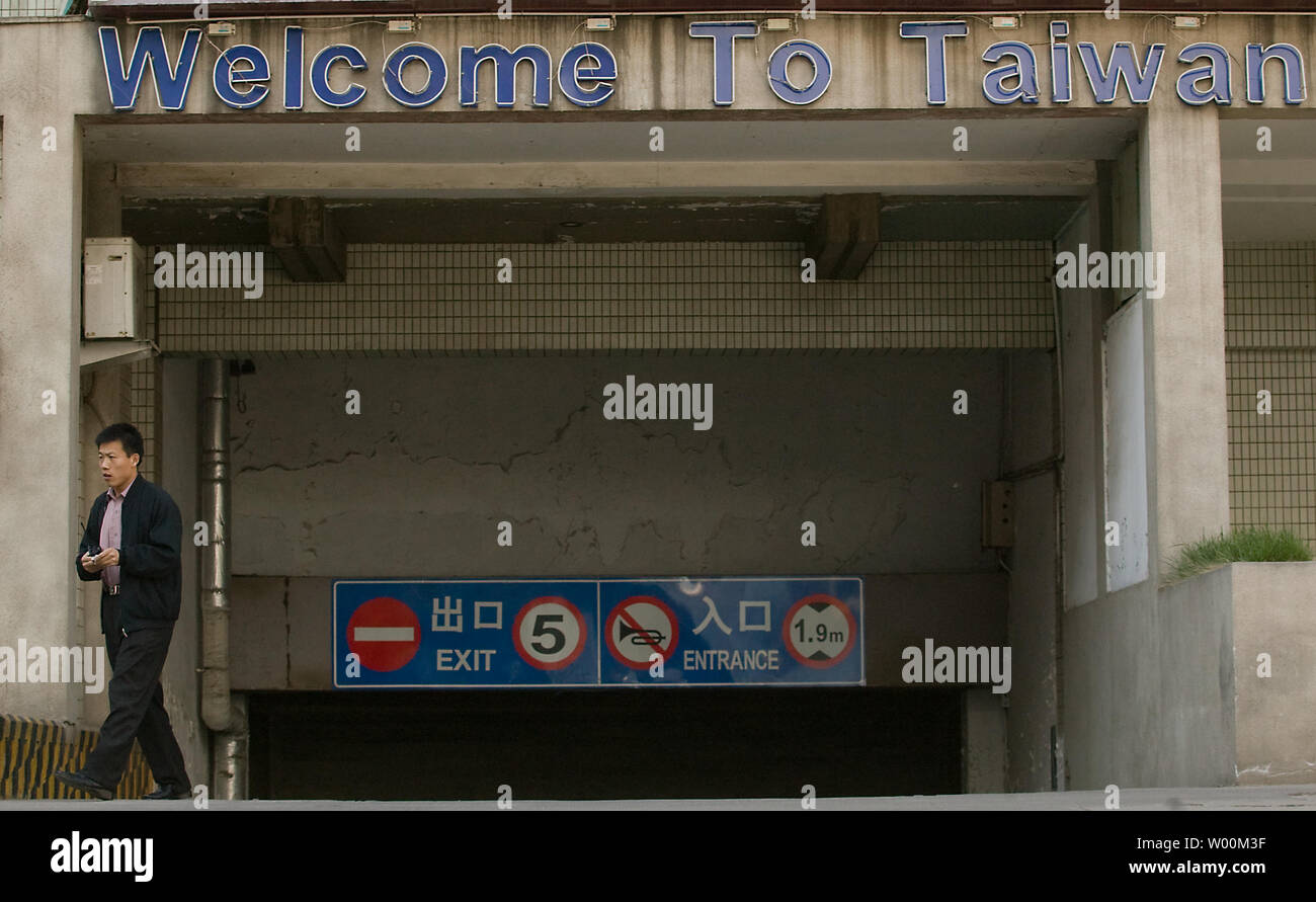 Un uomo cinese passeggiate passato il Taiwan Hotel dispone di garage per il parcheggio nel centro di Pechino il 3 aprile 2009. Cross-stretto le relazioni tra la Cina e Taiwan hanno scaldato dallo scorso anno, quando il Presidente taiwanese Ma Ying-jeou ha preso l'ufficio. Per parte sua, il premier cinese Wen Jiabao ha detto recentemente militari alla creazione di un clima di fiducia e di un accordo di pace con Taiwan sono ancora sul tavolo. (UPI foto/Stephen rasoio) Foto Stock