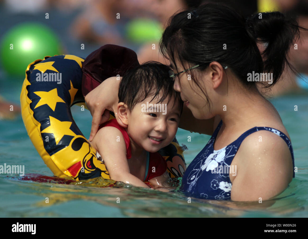 Cinesi e stranieri "beach frequentatori' visitare un parco locale della spiaggia "Carnival", dotate di vera sabbia e una grande piscina all'aperto a Pechino il 27 agosto 2009. Con temperature di questa estate colpendo punte record, medici avvisare hat persone potrebbero subire colpi di calore mentre fuori nel sole di mezzogiorno. UPI/Stephen rasoio Foto Stock