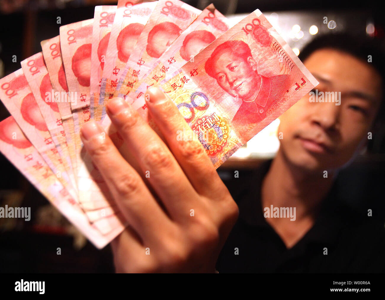 Un dipendente della banca detiene RMB100 banconote (USD15) a Pechino il 23 giugno 2010. La Cina ha sottoposto a una crescente pressione internazionale per modificare la sua politica monetaria. Gli Stati Uniti ha lamentato che la Cina si sta mantenendo artificialmente il valore dello yuan bassa per aiutare i suoi esportatori a scapito dei concorrenti esteri. UPI/Stephen rasoio Foto Stock