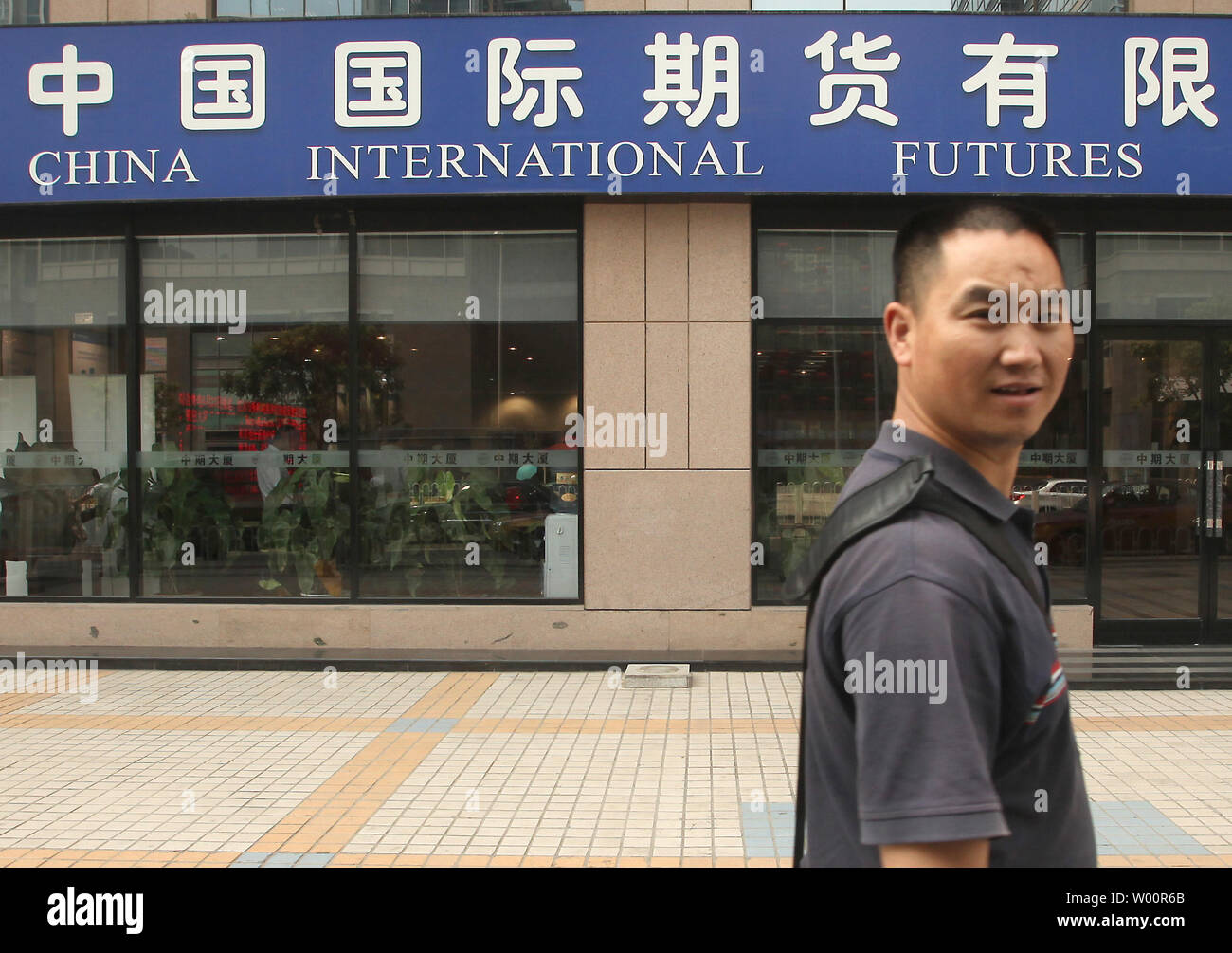 Un uomo cinese passeggiate passato una Cina International Futures succursale nel centro cittadino di Pechino il 24 giugno 2010. La Cina ha venuto increasinig sotto la pressione internazionale - in particolare da Stati Uniti e India - per modificare la sua politica monetaria. Gli Stati Uniti ha lamentato che la Cina si sta mantenendo artificialmente il valore della sua moneta bassa per aiutare i suoi esportatori a scapito dei concorrenti esteri. UPI/Stephen rasoio Foto Stock