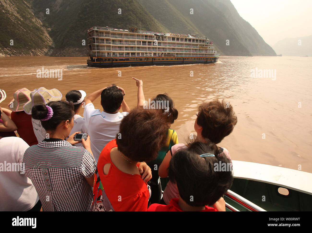 Crociera cinese e le navi mercantili immettere la prima delle Tre Gole, parzialmente sommerso a causa della diga delle Tre Gole, come essi portano i turisti lungo il fiume Yangtze, uno dei fiumi più trafficati del mondo, nel centro della provincia di Sichuan, 1 settembre 2010. La 600 km (373mi.) lungo il serbatoio allagato circa 1.300 siti archeologici e alterato l'aspetto delle Tre Gole, come il livello di acqua è salito oltre 180 metri (600 ft). Culturale e cimeli storici sono stati spostati a terra superiore così come essi sono stati scoperti, ma le inondazioni coperto molti siti. UPI/Stephen rasoio Foto Stock