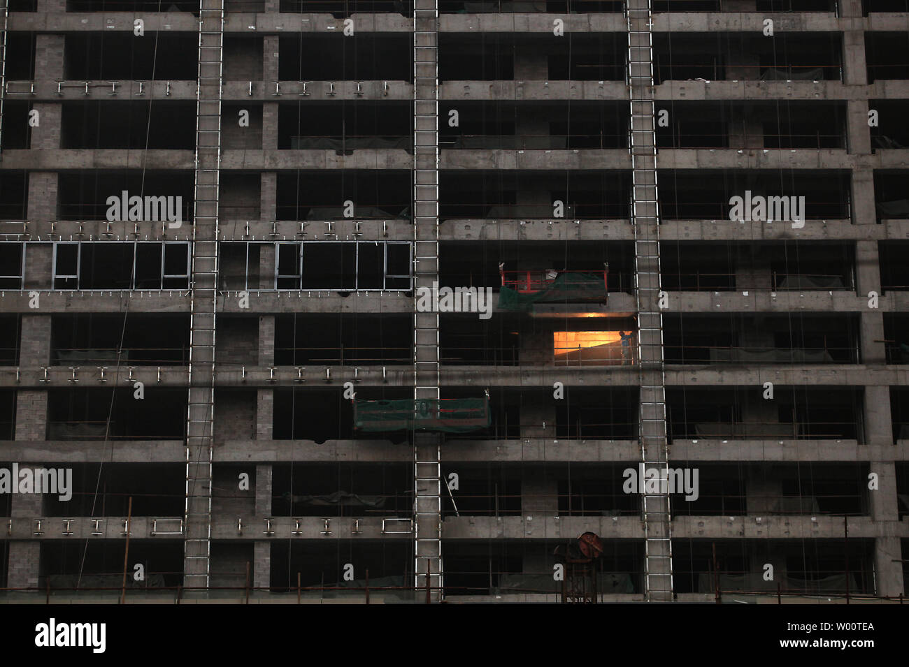 Una costruzione cinese operaio lavora su un massiccio edificio residenziale complesso nel centro di Pechino il 6 novembre 2010. La Cina può avere bisogno di investire fino a USD 2.600 miliardi in infrastrutture urbane nel 2020 per ospitare il crescente numero di residenti rurali muovendo verso la città, secondo un nuovo rapporto da parte di un governo think tank. UPI/Stephen rasoio Foto Stock