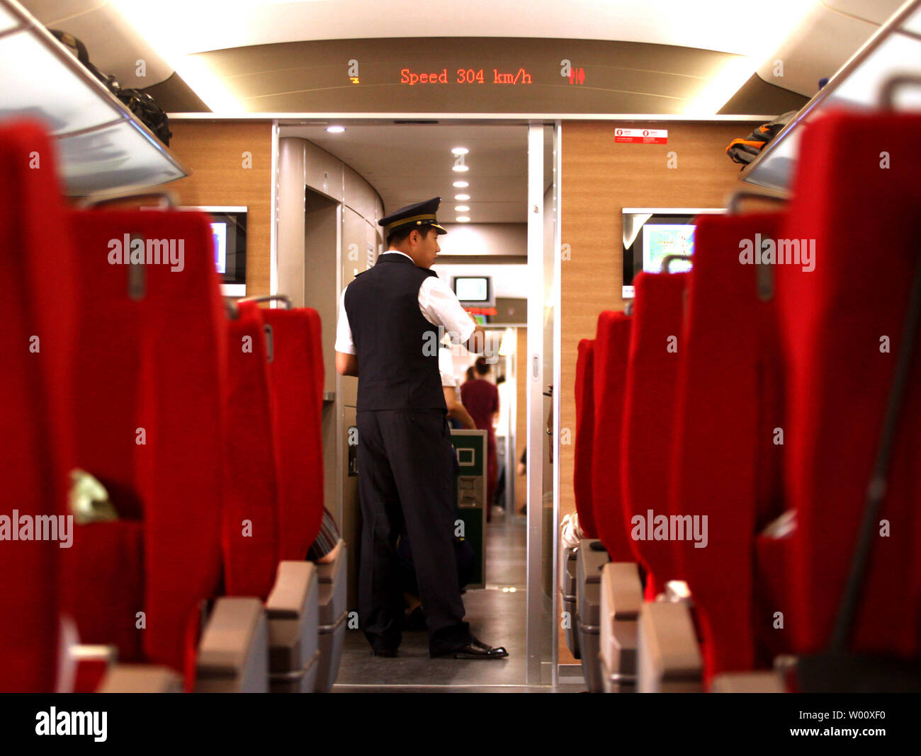 Un ospite cinese serve passeggeri su un CRH con il treno ad alta velocità denominato armonia, durante una prova su Pechino-per-linea di Shanghai il 27 giugno 2011. Ingegneri cinesi ha effettuato la prova del Beijing-Shanghai collegamento ferroviario ad alta velocità, giorni prima del suo lancio pubblico. Funzionari, giornalisti e boss della società erano a bordo per i 300km/h (190 mph) treno il viaggio inaugurale. UPI/Stephen rasoio Foto Stock