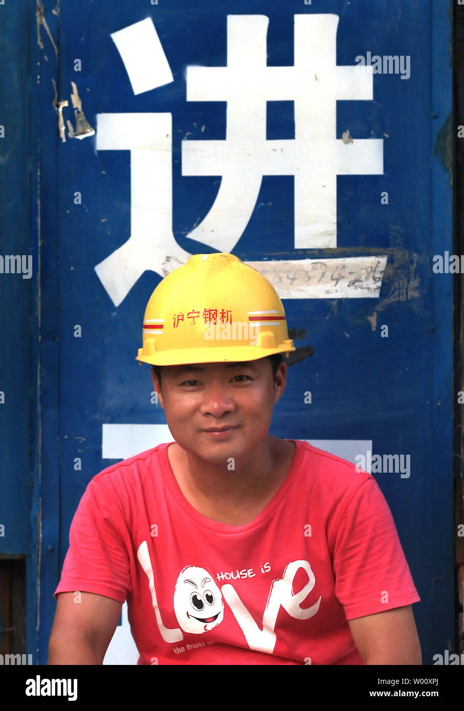 Un Cinese lavoratore edile si prende una pausa in un nuovo centro aziendale, progettato per assomigliare alla Olympic National Stadium, a Pechino il 31 luglio 2011. In tutta la Cina del capitale, il governo comunale sta cercando di raddoppiare le dimensioni del distretto centrale degli affari di Pechino, che ha già il più alto tasso di posto vacante mai registrata in città si aggirano intorno a 40-50%, secondo la Cina esperti in proprietà. "La Cina è il solo posto al mondo che pur avendo più edifici vuoti rispetto al resto del mondo ha ancora per riflettere tali valutazioni sul loro bilancio", presidente di Global Distre Foto Stock