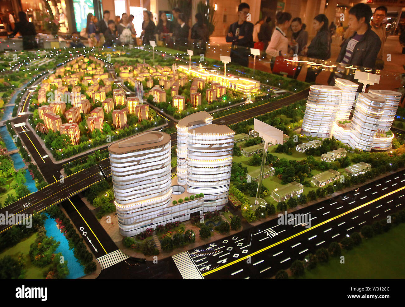 Cinese potenziali proprietari di casa guardare a un layout di grandi dimensioni di un nuovo quartiere residenziale e commerciale di progetto ora in costruzione e con unità di vendita a Pechino il 26 novembre 2012. Casa di proprietà una volta impossibile in Cina a causa di proprietà del governo del land, è stata interrogata come il più importante sogno della maggior parte dei cinesi, secondo i media di stato. UPI/Stephen rasoio Foto Stock