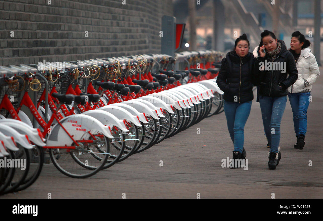 Decine di pubblico noleggio di biciclette sono parcheggiate presso un self-service bike kiosk su una strada a Pechino il 15 gennaio 2014. Nonostante il rapido aumento in possesso di auto in tutta la Cina, il paese è rimasto impegnato per i ciclisti con piste ciclabili di essere parte integrante di ogni città della rete di trasporto. UPI/Stephen rasoio Foto Stock