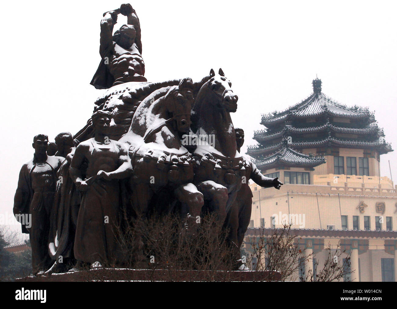 La neve copre una rivoluzione culturale statua nei pressi di un centro espositivo a Pechino il 7 febbraio 2014. È la prima neve per colpire la Cina del capitale in quanto l'inverno è iniziato lo scorso anno. UPI/Stephen rasoio Foto Stock