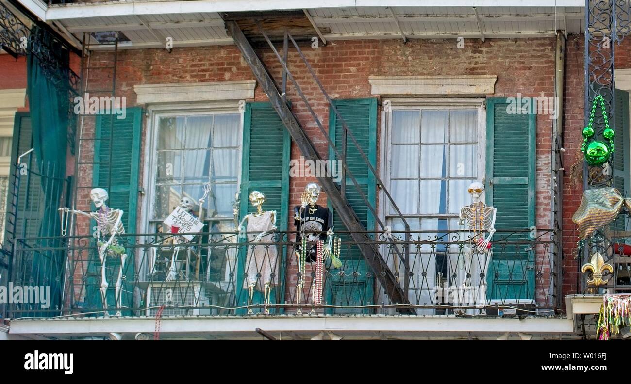 Scheletri adornati con gioielli Mardi Gras sedersi su un balcone portico di una casa di New Orleans Foto Stock