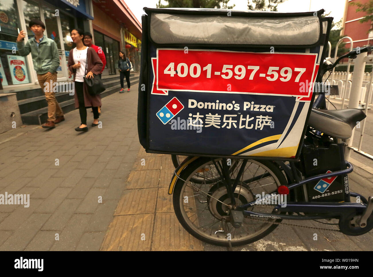 Il cinese a piedi passato di recente apertura del Domino Pizza franchising nel centro cittadino di Pechino il 5 novembre 2015. La cultura americana, specialmente il cibo, abbigliamento, musica e film, è ampiamente promossa in tutta la Cina le principali città come il paese continua ad aprirsi alla cultura occidentale. Foto di Stefano rasoio/UPI Foto Stock