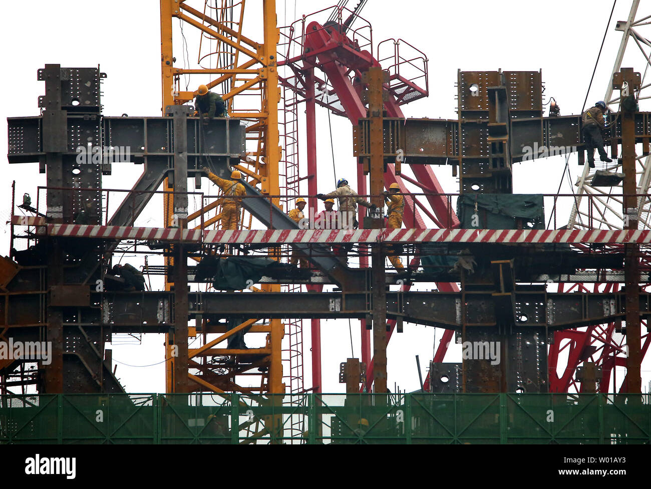 Lavoratori cinesi operano su travi in acciaio a un nuovo sito in costruzione nel quartiere centrale degli affari di Pechino il 19 aprile 2016. La Cina ha difeso con fermezza gli sforzi per affrontare la crisi siderurgica questa settimana, ribattere alle accuse che la sua economici delle esportazioni di acciaio sono state provocando chiusure di stabilimenti e la perdita di posti di lavoro in tutto il mondo. Foto di Stefano rasoio/UPI Foto Stock