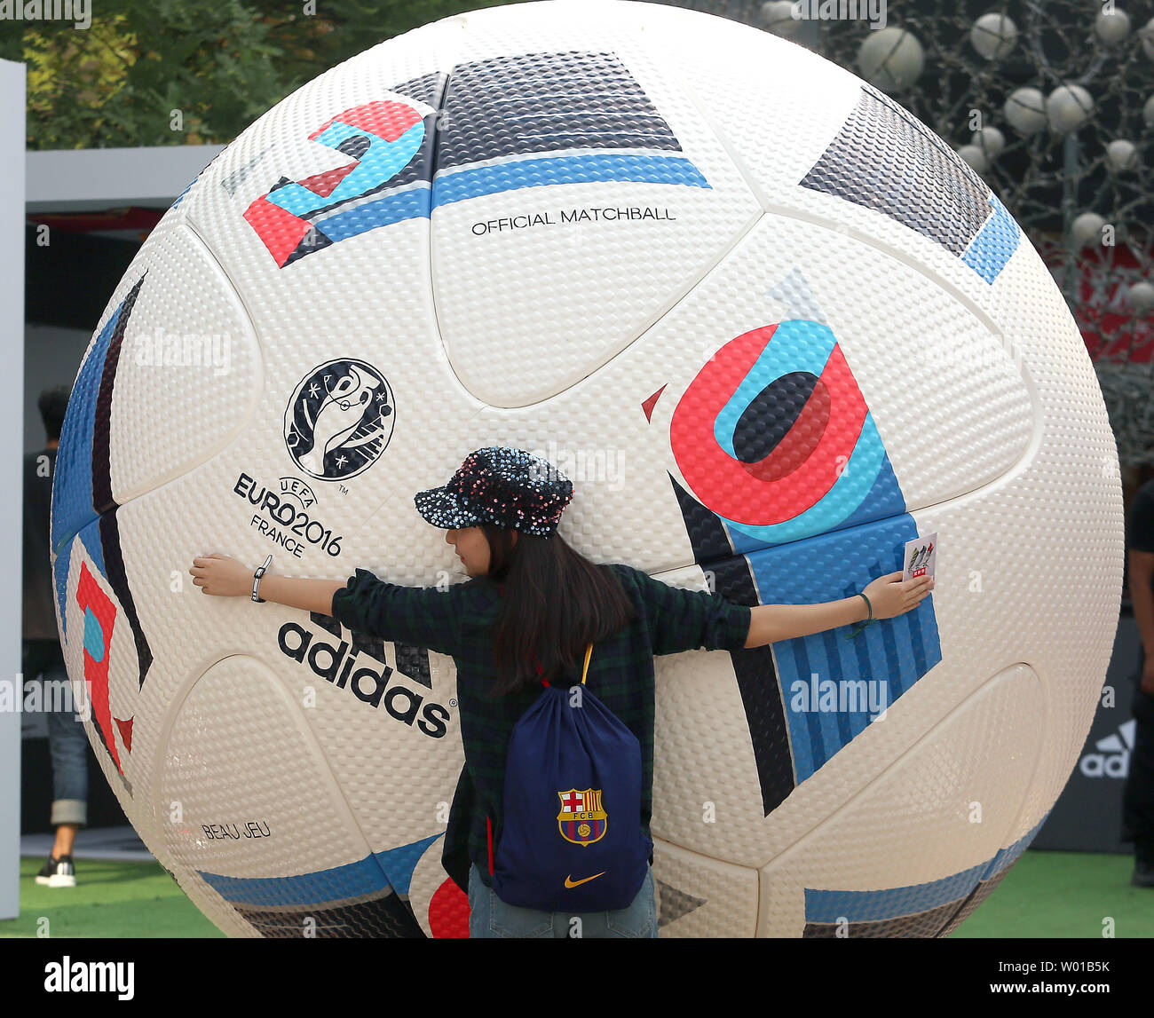 Una donna cinese abbraccia un enorme pallone da calcio, una replica della  gazzetta palla calcio essendo utilizzato in EURO2016 giochi, sul display a  Pechino il 13 giugno 2016. La Cina del Presidente
