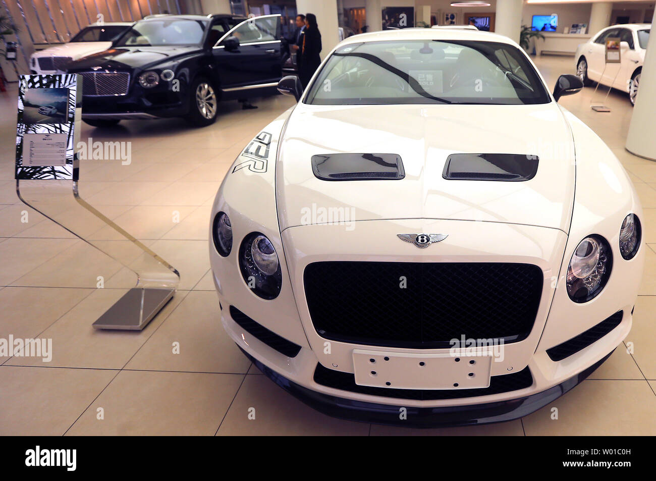 Cinese di guardare a nuovi Bentley in uno showroom in centro a Pechino il 3 dicembre 2016. La Cina ha imposto un dieci per cento imposta su ultra high-end di lusso auto al costo di oltre $ 190.000 come Ferraris, Bentley, Aston Martins, Maserati, Lamborghini e Rolls-Rocye vetture di una repressione capillare sul consumo cospicuo e innesto, promuovendo al contempo la più efficiente del carburante dei veicoli. Foto di Stefano rasoio/UPI Foto Stock