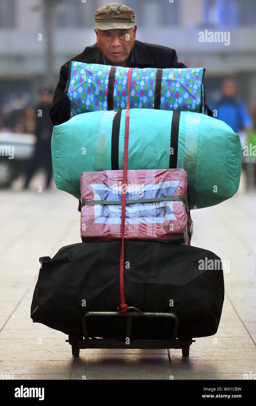 Un uomo cinese lascia un centro commerciale con sacchi pieni di merci a Pechino il 6 febbraio 2017. Relazioni internazionali e cinese-marchi fatti suggeriscono la spesa in Cina è in ripresa dopo un paio di anni difficili causati dalla Cina la campagna anti-corruzione e debole la fiducia dei consumatori, secondo Fitch. Foto di Stefano rasoio/UPI Foto Stock