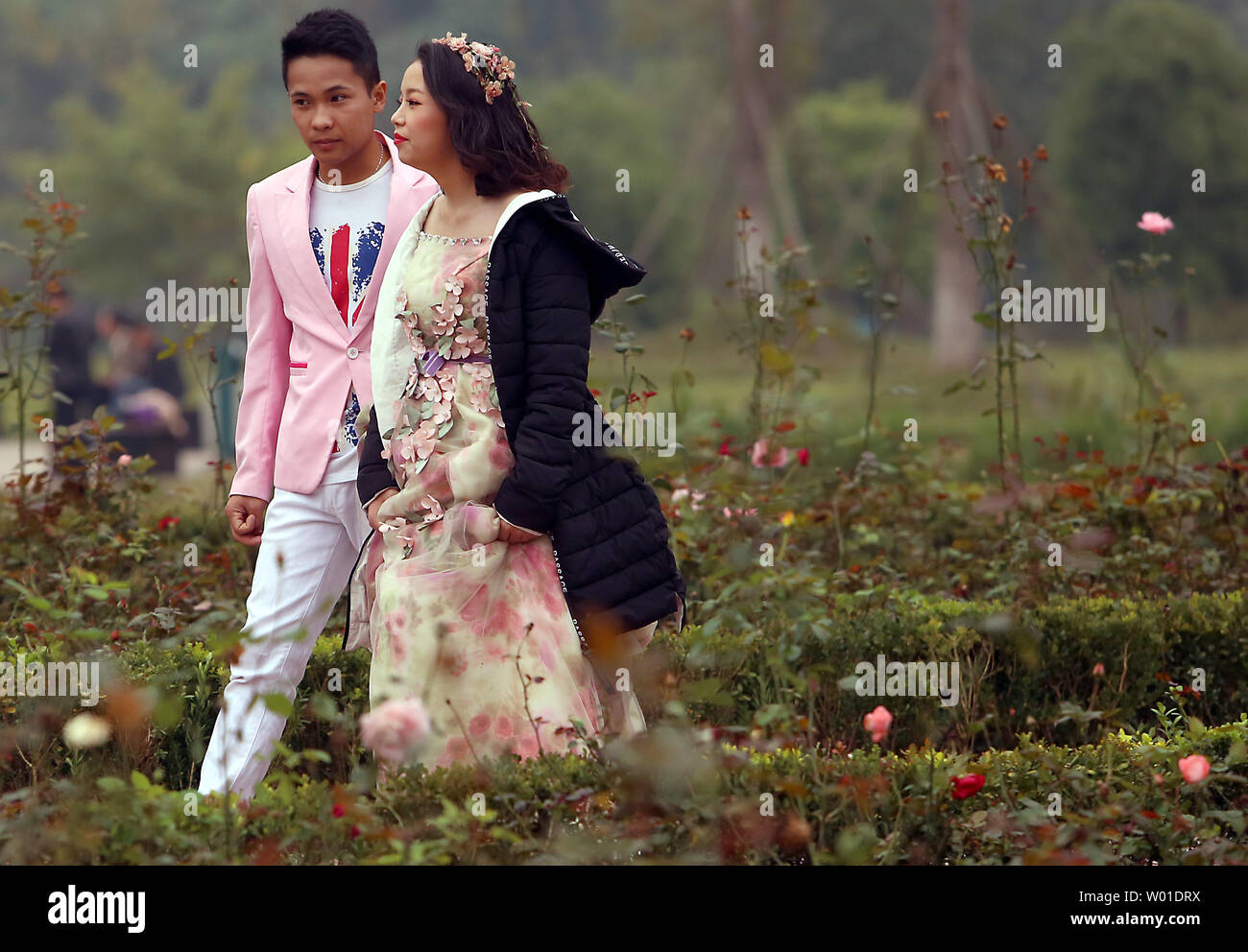 Un giovane cinese giovane passeggiate attraverso un parco sul loro modo ad un wedding photo shoot vicino a Pechino il 13 dicembre 2017. Atteggiamenti nei confronti della tradizionale matrimonio cinese sono state influenzate dai paesi occidentali, con più coppie oggi optare per il Western-style matrimoni. Foto di Stefano rasoio/UPI Foto Stock