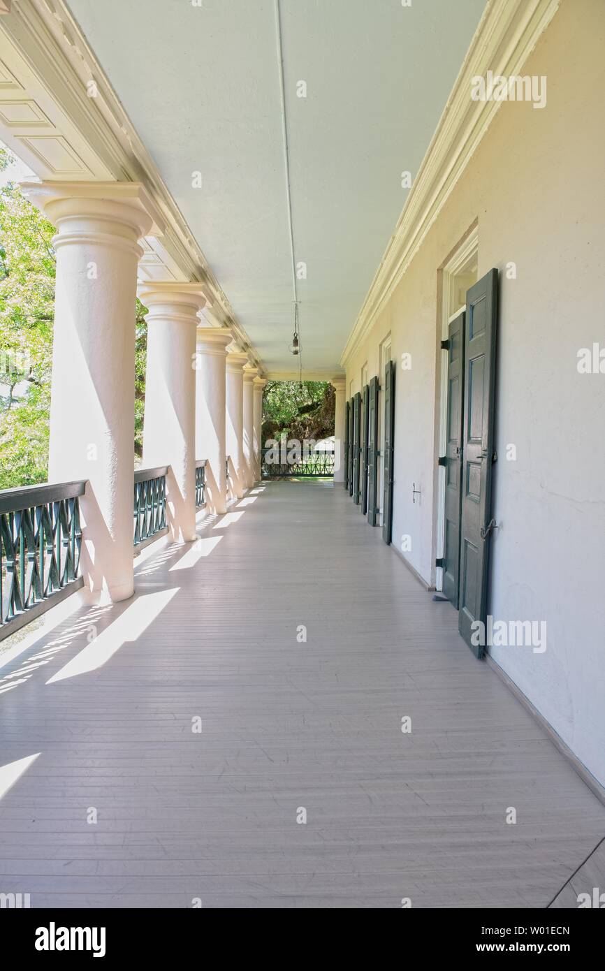 Una vista lungo un corridoio esterno di edifici di revival greci con colonne Foto Stock