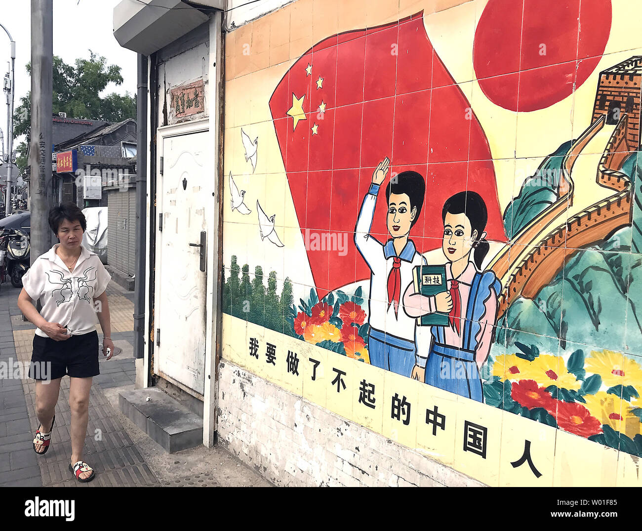 Una donna cinese passeggiate passato un murale sponsorizzato dal locale Partito Comunista promuovendo le virtù del socialismo a Pechino il 15 luglio 2018. Vi è stata una ripresa in pubblico i segni e i murales promuovendo le virtù del comunismo e socialismo dopo l elezione del Presidente cinese Xi Jinping. Foto di Stefano rasoio/UPI Foto Stock