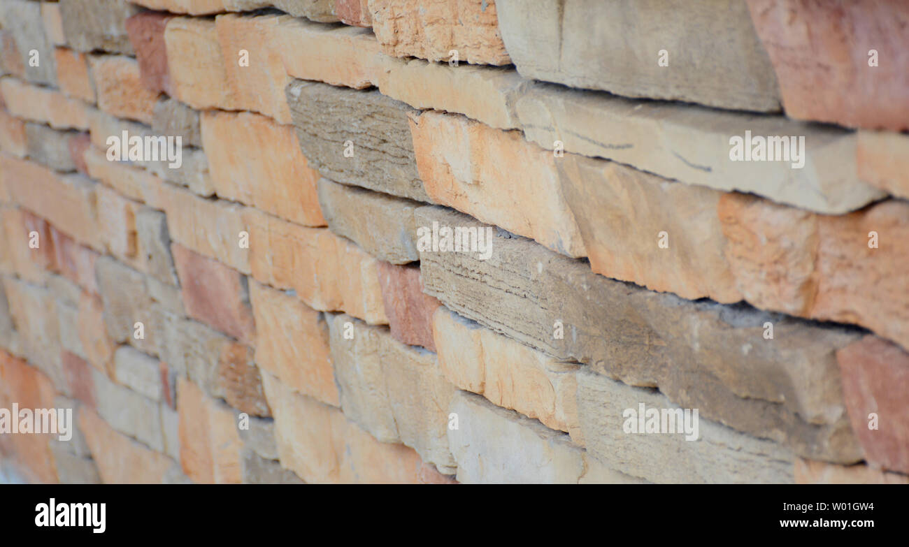 Si tratta di un bel muro di mattoni in stile rustico con diversi colori e texture Foto Stock