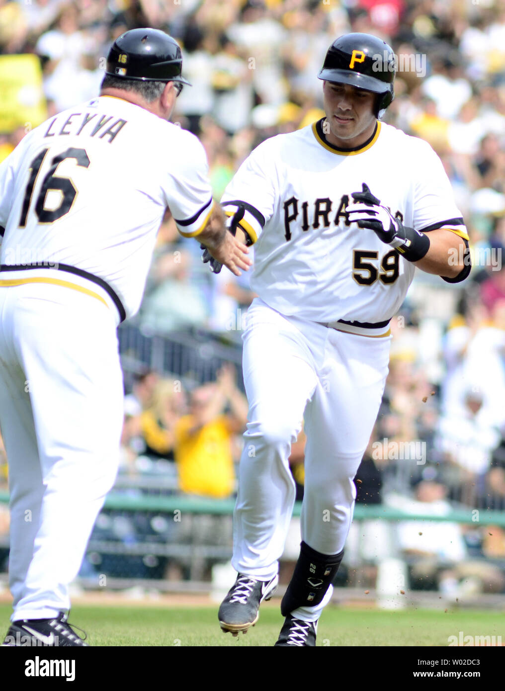 Pittsburgh Pirates catcher Tony Sanchez (59) saluta i pirati terza base allenatore Nick Leyva (16) come egli arrotonda le basi seguendo il suo homerun nel quarto inning contro il Chicago Cubs al PNC Park di Pittsburgh, il 15 settembre 2013. UPI/Archie Carpenter Foto Stock
