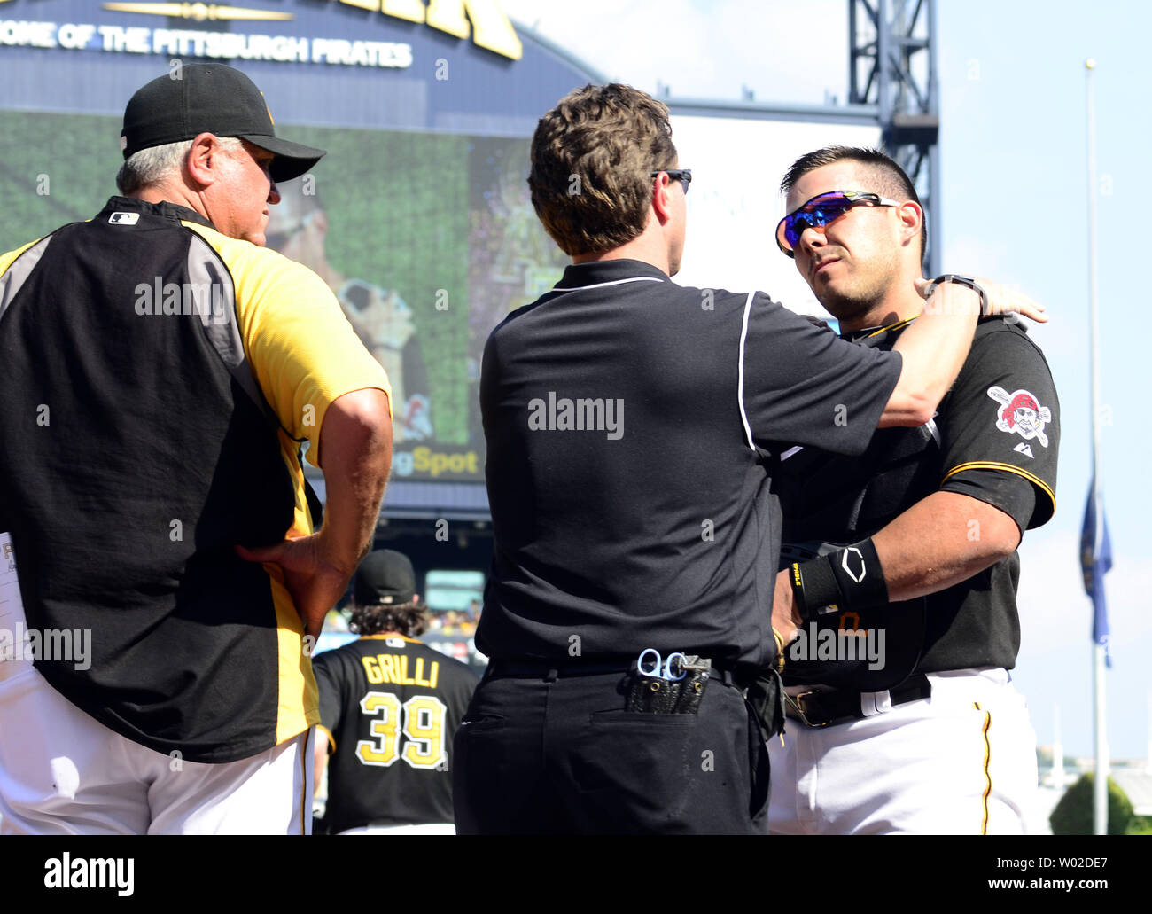 I pirati trainer con i Pirati di Pittsburgh manager Clint Hurdle (13) si affaccia su come i pirati trainer esamina i pirati di Pittsburgh catcher Tony Sanchez (59) dopo il catcher cade Head over heels in San Diego Padres piroga ma tiene a sfera per la nell'ottavo inning del 10-1 vincere contro i San Diego Padres al PNC Park di Pittsburgh, il 19 settembre 2013. UPI/Archie Carpenter Foto Stock