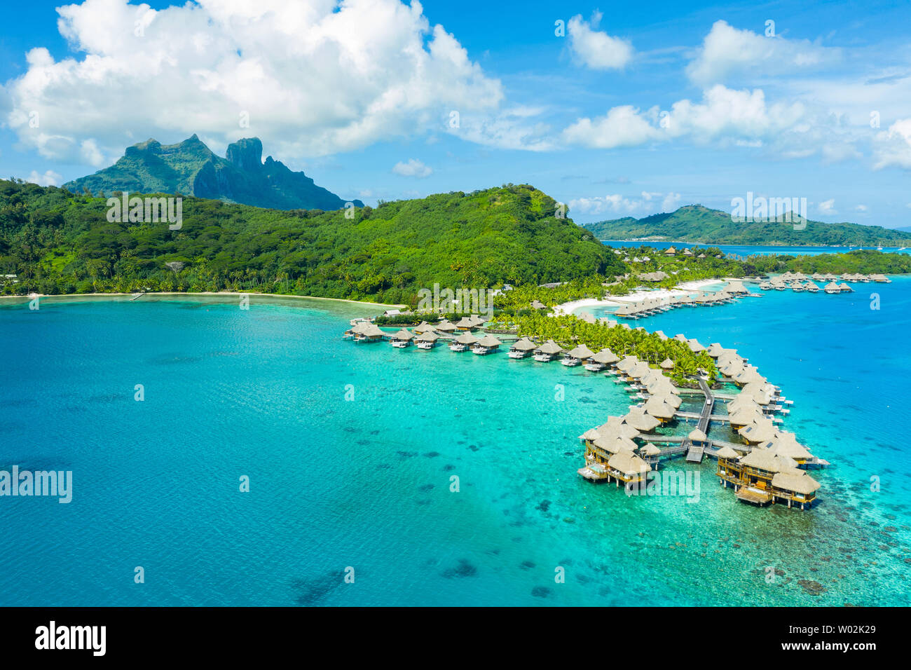 Travel Vacation paradise antenna fuco video con bungalow Overwater resort di lusso in Coral reef lagoon ocean beach. Antenna di Monte Otemanu, Bora Bora, Polinesia francese, Tahiti, Oceano Pacifico del Sud Foto Stock