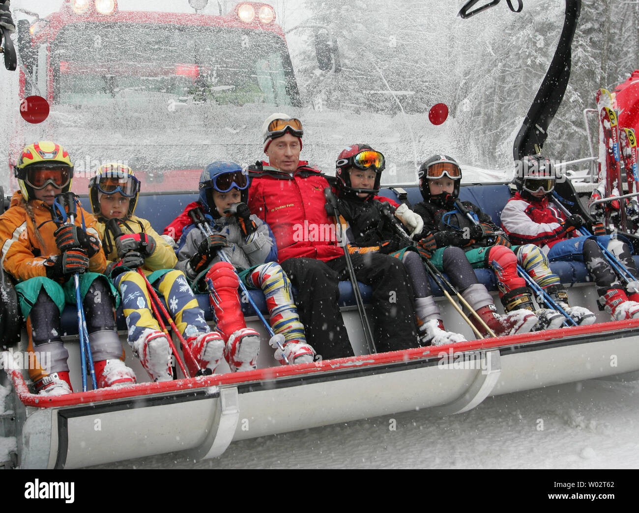 Il presidente russo Vladimir Putin si siede con i bambini da una locale scuola di sport in attesa di essere sollevato fino alla montagna nella Krasnaya Polyana area al di fuori della località del Mar Nero di Sochi, Russia il 20 febbraio 2007. Putin ha visitato la cresta Psekhako ski area, una nuova struttura nella Krasnaya Polyana area in cui la Russia sta proponendo tenendo la neve eventi sportivi per il 2014 Giochi Olimpici Invernali. (UPI foto/Anatoli Zhdanov) Foto Stock