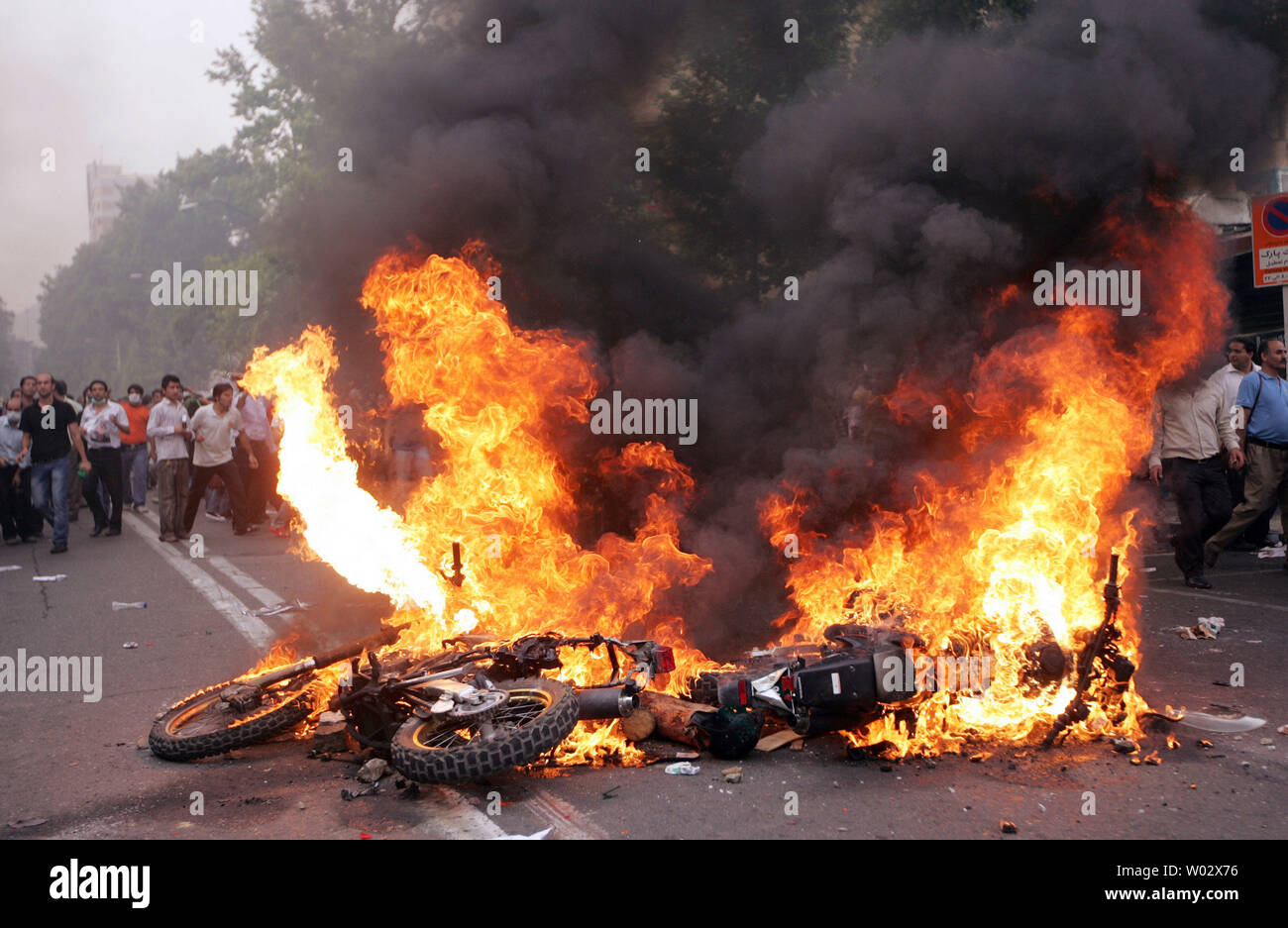Un motociclo brucia come i sostenitori del candidato riformista Mir Hossein Mousavi si riuniscono sulle strade per protestare contro i risultati del Iraniano elezione presidenziale in Tehran, Iran il 13 giugno 2009. UPI Foto Stock