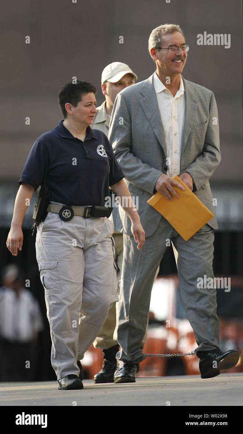 Finanziere R. Allen Stanford (R) è scortato in Federal Courthouse in manette per un' audizione su se un ordine concessione lui bail dovrebbe essere invertita a Houston, in Texas, il 29 giugno 2009. Stanford è stato incriminato da un gran giurì federale insieme ad altre cinque persone tra cui un ex regolatore Antiguan su oneri hanno diretto a 7 miliardi di dollari di frode per la vendita di certificati di deposito attraverso la sua banca Antiguan. (UPI foto/Aaron M. Sprecher) Foto Stock