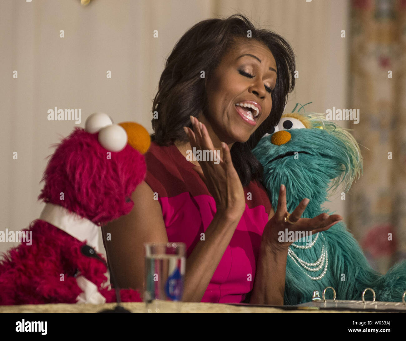 La First Lady Michelle Obama si unisce con sesamo Street di Elmo e Rosita in un annuncio di partner in una campagna di marketing per aiutare i bambini a mangiare alimenti più sani, in corrispondenza di un evento nello stato in sala da pranzo della Casa Bianca di Washington il 30 ottobre 2013. Il trio più successivamente ha unito i bambini in calo annuo raccolto della Casa Bianca Orto. UPI/Pat Benic Foto Stock