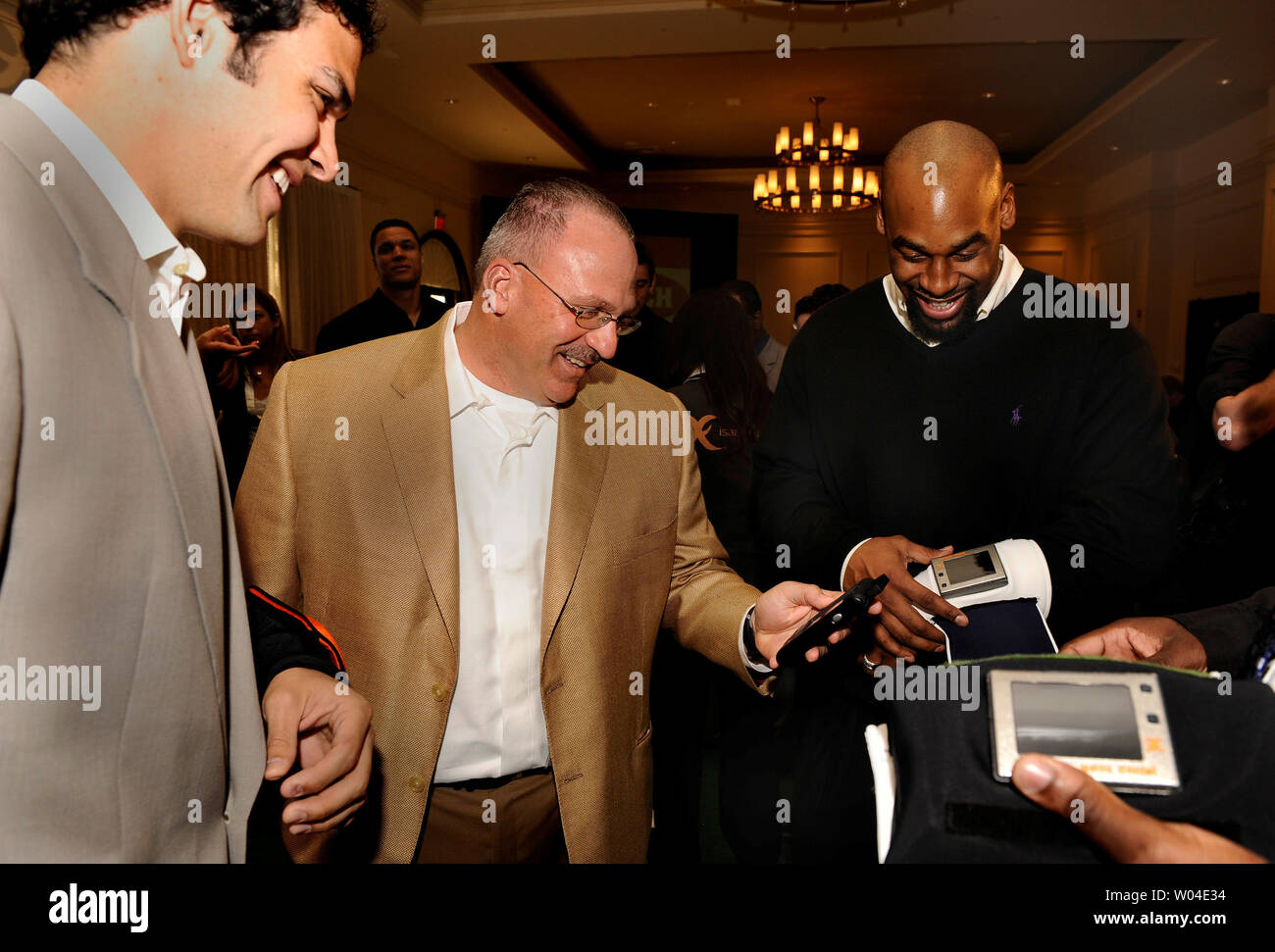 NFL Miami Dolphins head coach Tony Sparano (C) parla di una nuova tecnologia wireless denominato ID pullman con quarterbacks Donovan McNabb di Philadelphia Eagles (R) e Mark Sanchez, precedentemente della University of Southern California nel corso di una conferenza stampa ospitata dalla tecnologia azienda Issac Daniel gruppo su gennaio 31, 2009 a Tampa, in Florida. La tecnologia funziona quando il quarterback indossa un braccialetto dotato di un piccolo schermo LCD visualizzazione gioca inviato da criptato comunicazione wireless dall'emarginare coach usando una unità palmare. (UPI foto/Mike Theiler) Foto Stock