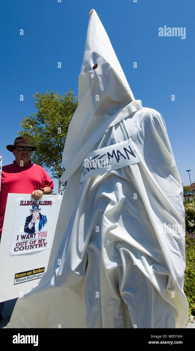 Un sistema anti- Minutemen protester indossando un KKK fuori montare stava con i membri del Minutemen anti-immigrazione gruppo durante un pro-immigrazione nel rally di San Diego, California, 3 giugno 2006. L'uomo è stato successivamente portano lontano dalla polizia. (UPI foto/Earl S. Cryer) Foto Stock