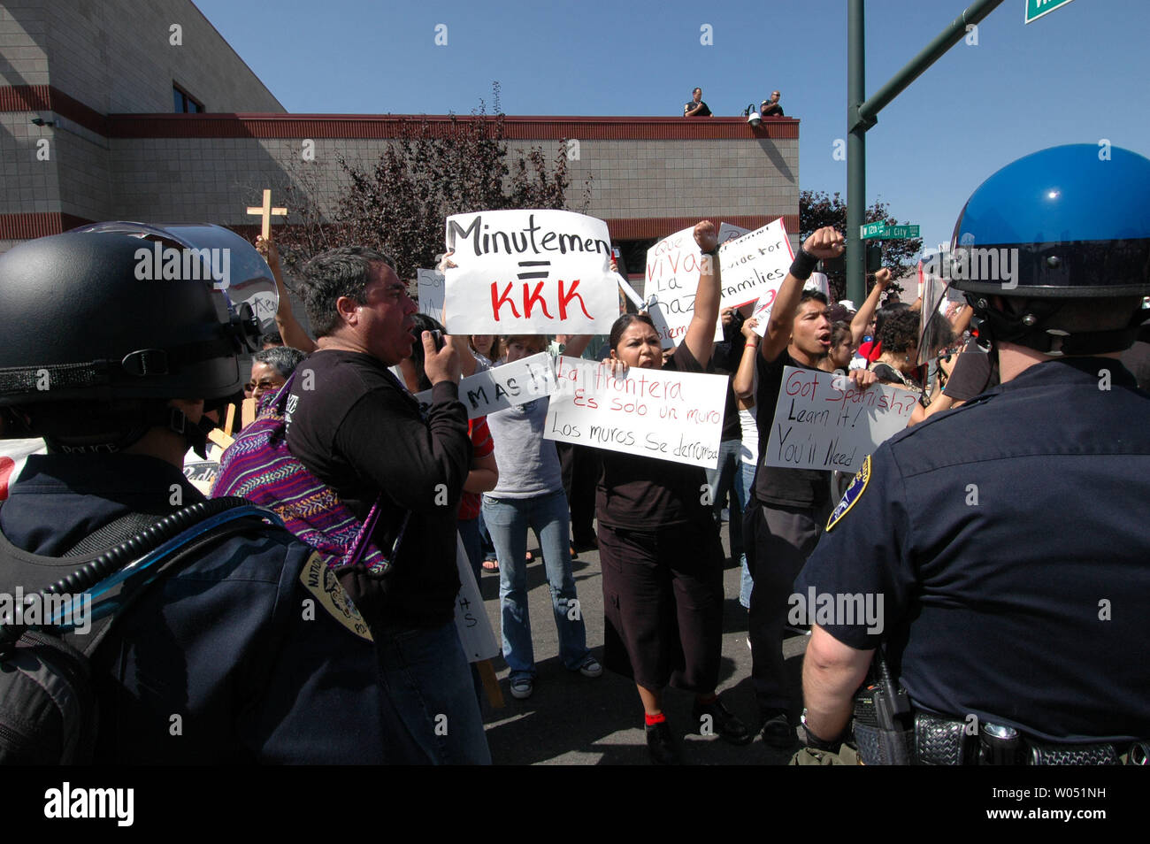 Sheriff deputati e delle forze di polizia locali vegli su di un gruppo di ispanici contro i manifestanti, opponendosi alla anti-illegale-immigrazione gruppo attivista, il San Diego Minutemen, come protestano contro National City, California e il suo sindaco, Nick Inzunza il 23 settembre 2006. Inzunza vuole Nazionale Città, appena a nord del confine messicano per diventare un santuario per gli immigrati clandestini. (UPI foto/Earl S. Cryer) Foto Stock