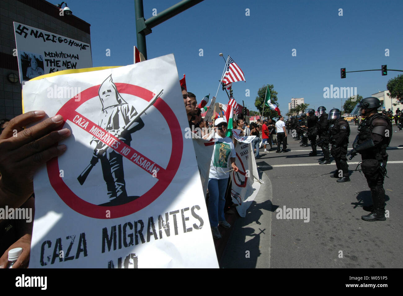 Sheriff deputati e delle forze di polizia locali vegli su di un gruppo di ispanici contro i manifestanti, opponendosi alla anti-illegale-immigrazione gruppo attivista, il San Diego Minutemen, come protestano contro National City, California e il suo sindaco, Nick Inzunza il 23 settembre 2006. Inzunza vuole Nazionale Città, appena a nord del confine messicano per diventare un santuario per gli immigrati clandestini. (UPI foto/Earl S. Cryer) Foto Stock