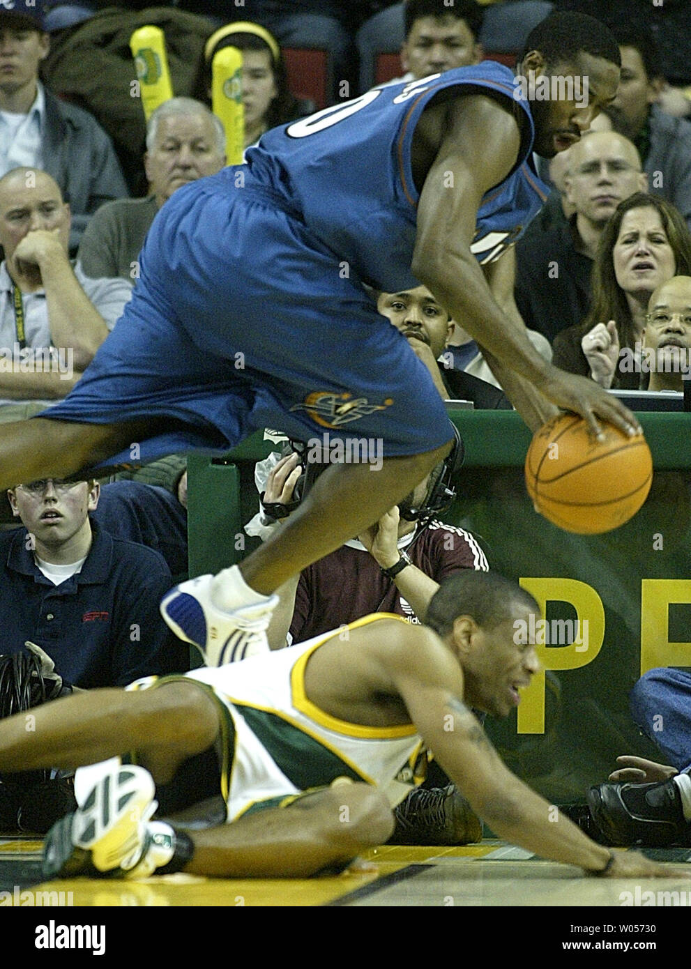 Washington Wizards' Gilbert Arenas balzi su Seattle Supersonics' Antonio Daniels mentre andando per una sfera allentato nella seconda metà delle procedure guidate 95-94 conquistare il SuperSonics a Seattle il 27 marzo 2005. (UPI foto/Jim Bryant) Foto Stock