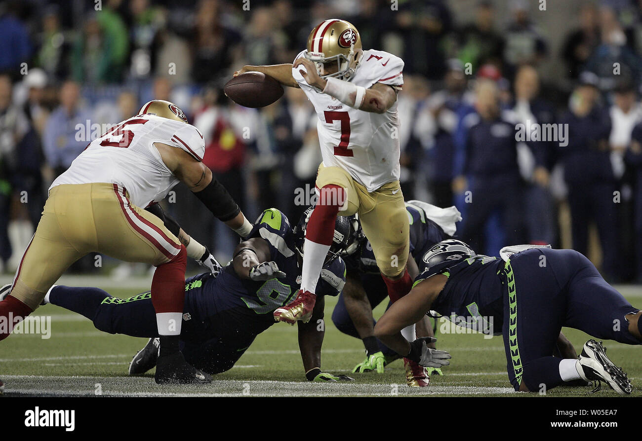 San Francisco 49ers quarterback Colin Kaepernick codifica contro Seattle Seahawks difensori Chris Clemons (91), O'Brien Schofield (93), e Michael Bennett (72) nel quarto trimestre a Campo CenturyLink a Seattle, Washington, il 15 settembre 2013. La difesa di Seattle detenute Kaepernick a 142 passando cantieri, 87 rushing yards e intercettato lui per tre volte il Seahawks 29-3 conquistare il 49ers. UPI/Jim Bryant Foto Stock