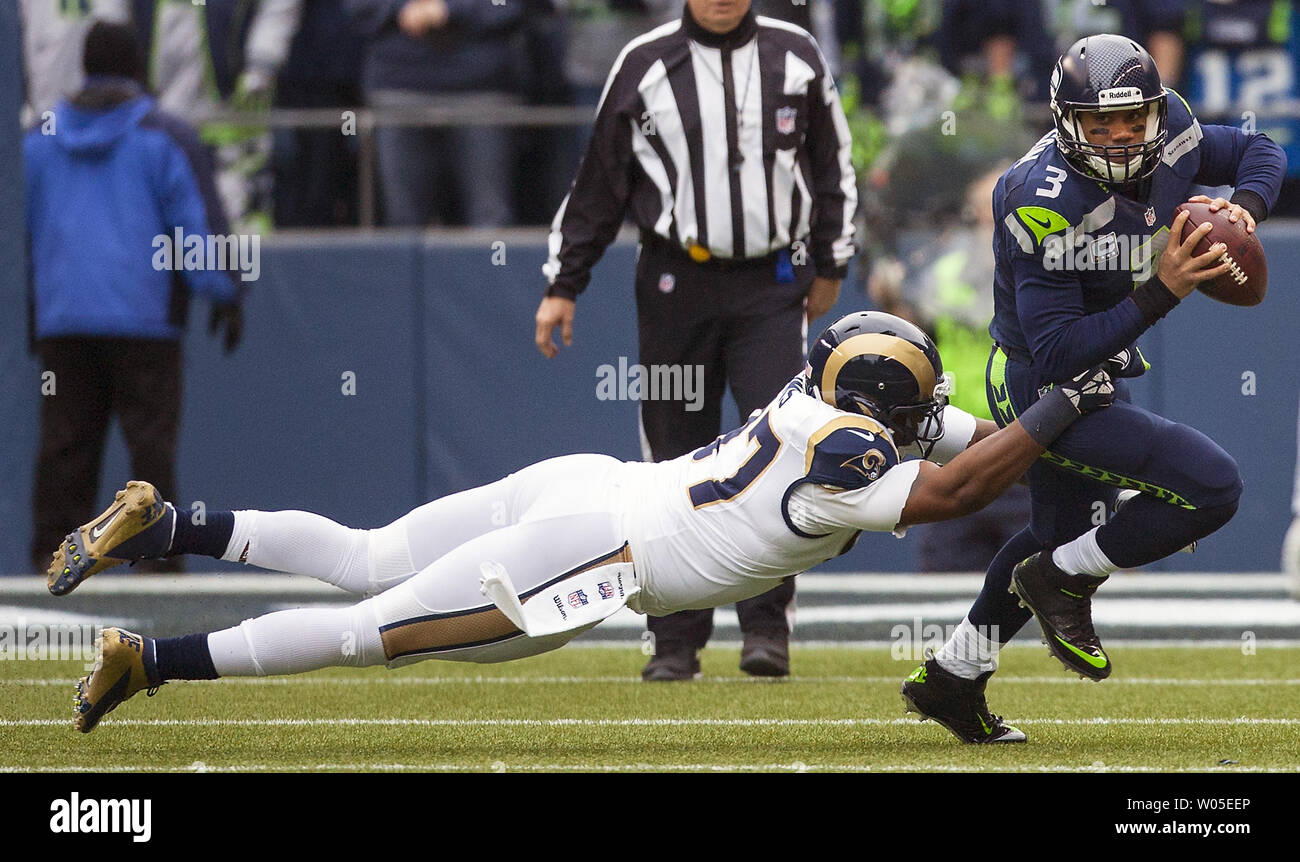 Seattle Seahawks quarterback Russell Wilson (3) viene affrontato per un periodo di sei metri perdita da San Louis Rams Eugene Sims (97) nel quarto trimestre a Campo CenturyLink a Seattle, Washington, il 29 dicembre 2013. Seahawks conquistato il NFC West titolo e home-campo vantaggio durante i playoff con una vittoria 27-9 su San Louis Rams. Wilson completato 15 di 23 passa per 172 yards e un touchdown nella vittoria. UPI /Jim Bryant Foto Stock