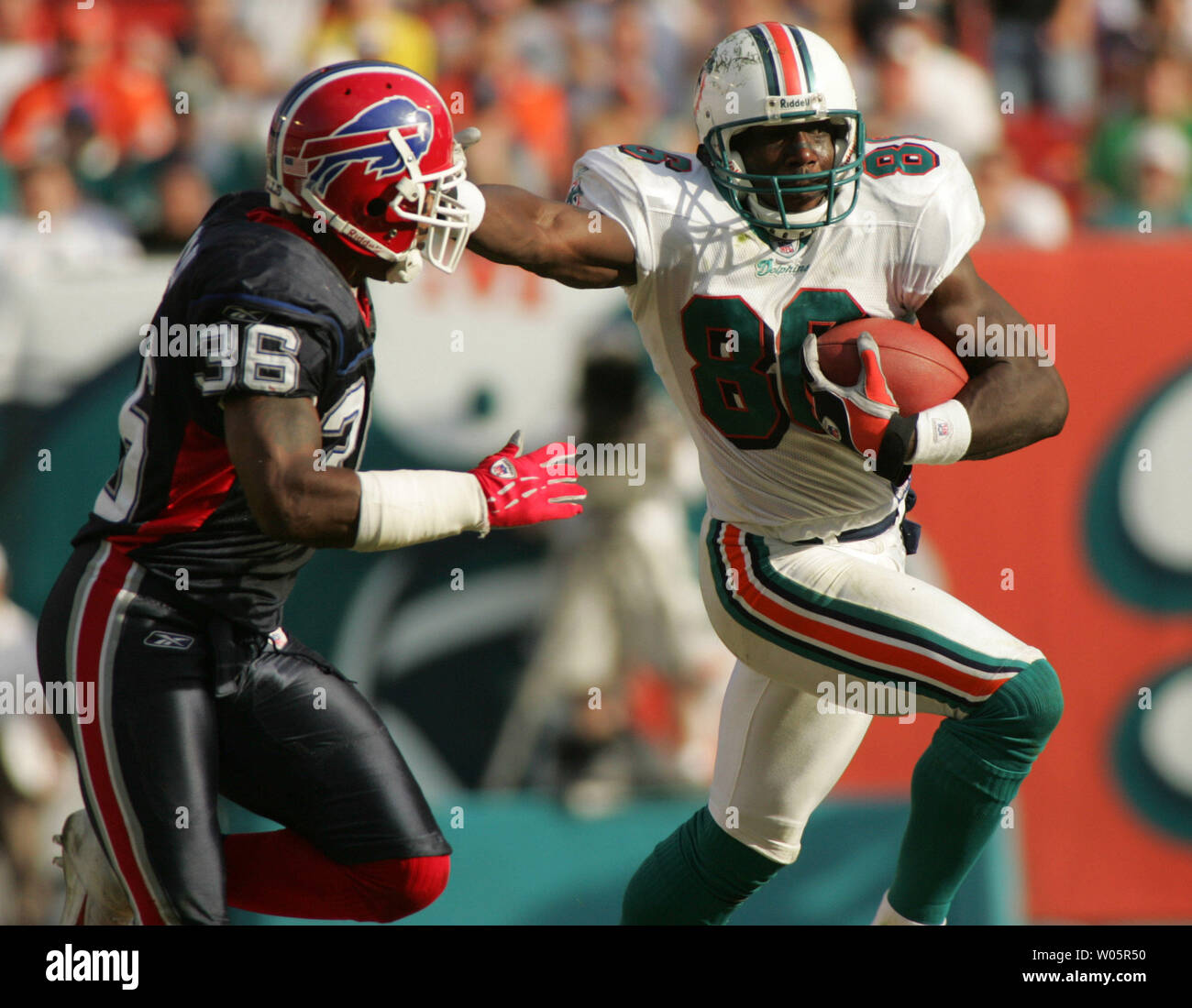 Miami Dolphins wide receiver Marty Booker (86) guadagna yardage contro Buffalo's avvocato Milloy (36) il 5 dicembre 2004 durante il primo semestre azione contro le fatture della Buffalo al Pro Player Stadium di Miami , FL. Le fatture della Buffalo battere i delfini di Miami 42-32. (UPI foto/Susan Knowles) Foto Stock