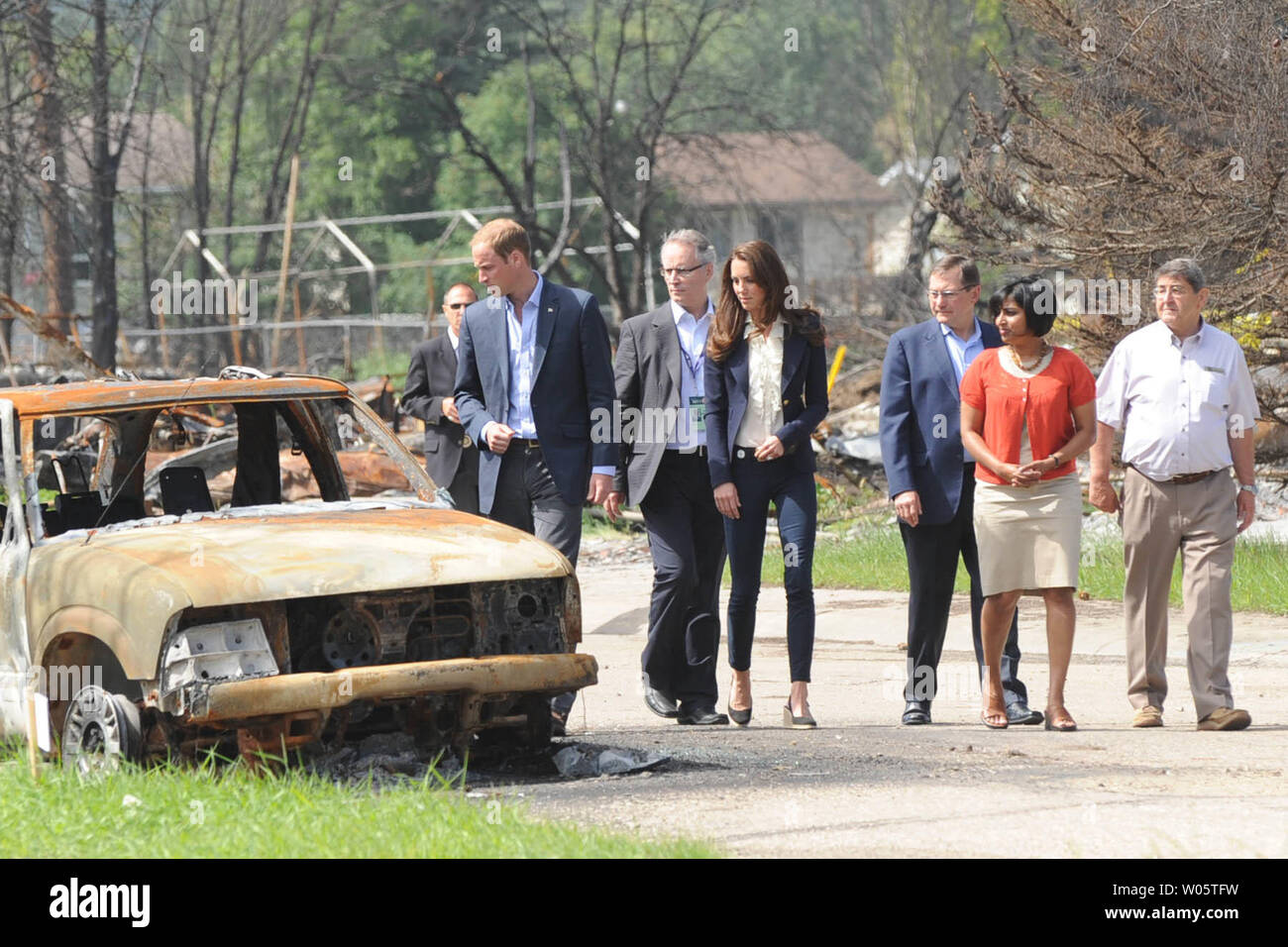 Sindaco Karina Pillay-Kinee (maglione rosso) accompagnatrici il principe William e sua moglie Kate, il Duca e la Duchessa di Cambridge, in una passeggiata attraverso un incendio di foresta zona devastata durante la loro visita improvvisata a Slave Lake, Pillay-Kinee piccolo Albertan settentrionale comunità, Luglio 6, 2011. UPI/hr/patrimonio di cortesia in Canada Foto Stock