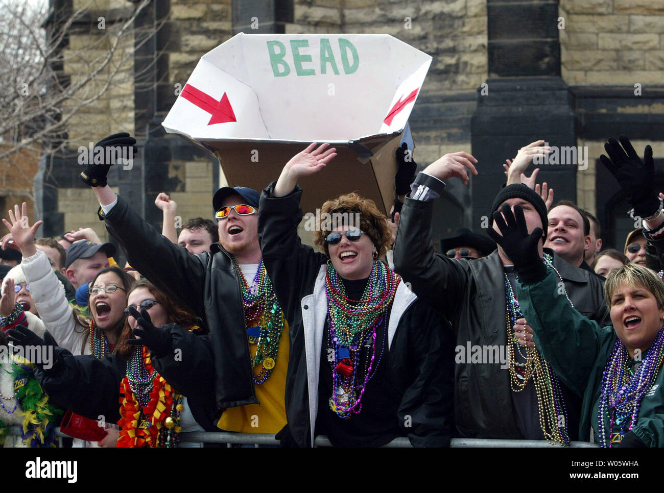 Una sfilata intelligente goer alletti t5tubo gettando perle da galleggianti, per colpire il suo target di grandi dimensioni durante il St. Louis Mardi Gras Parade di San Louis il 21 febbraio 2004. La Parade, seconda lartgest solo a New Orleans è stato divertente San Louisians per oltre vent'anni. (UPI foto/Bill Greenblatt) Foto Stock