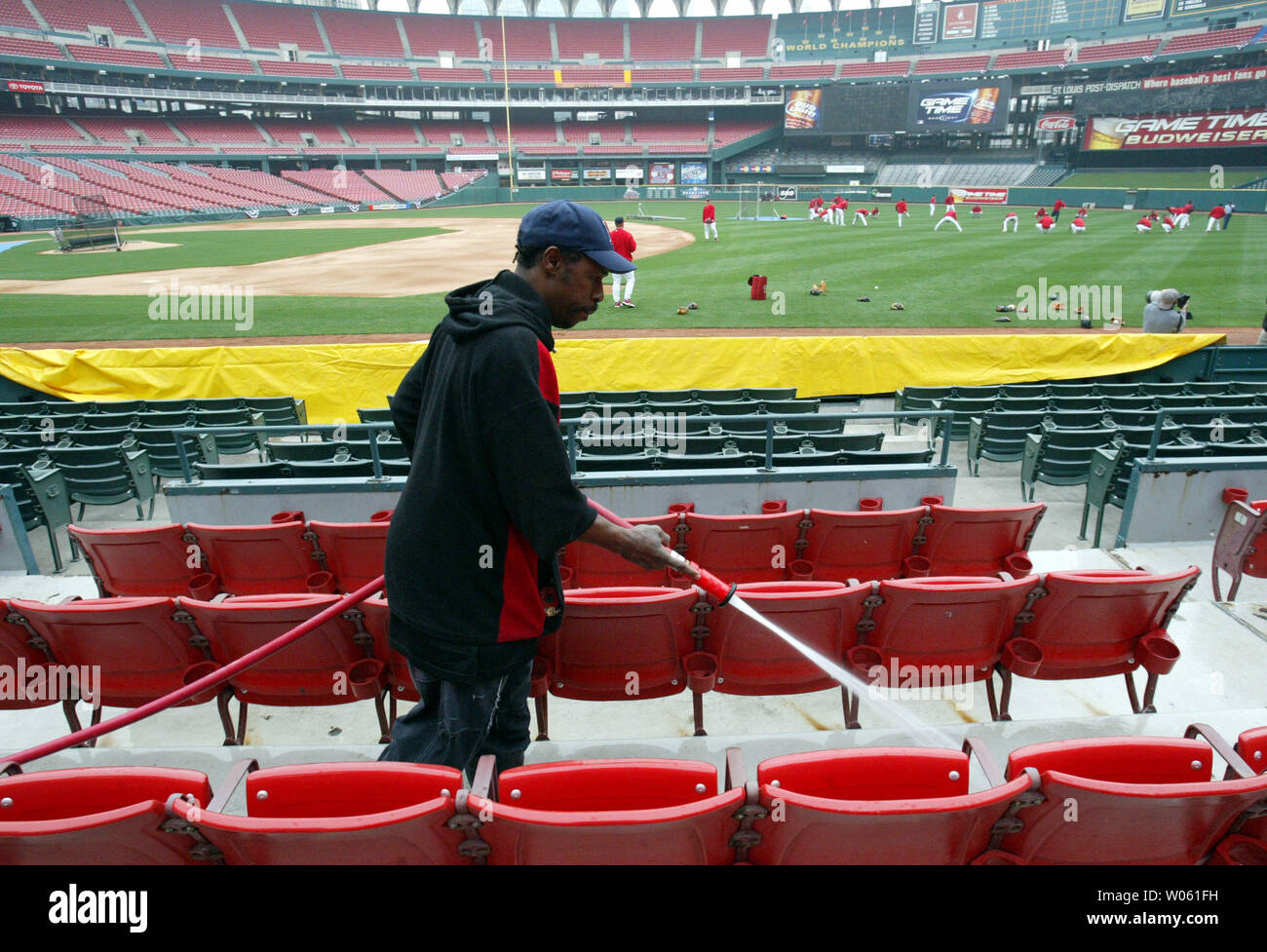 Lavoratore Paul Lee i tubi flessibili verso il basso l'area con posti a sedere mentre il St. Louis Cardinals allenamento sul campo al Busch Stadium di St Louis il 7 aprile 2005. I Cardinali giocheranno Filadelfia il 8 aprile l'ultimo home opener al Busch Stadium che è programmato per essere rasa al suolo nel dicembre del nuovo Stadio Busch essendo costruito accanto. (UPI foto/Bill Grreenblatt) Foto Stock