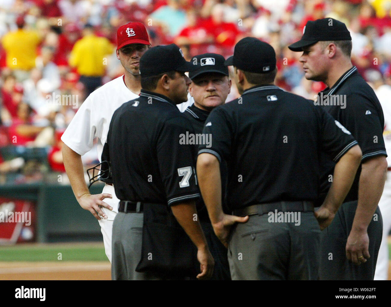 Louis Cardinals brocche Chris Carpenter (L) attende come arbitri (L a R) Alfonso Marquez, Terry Craft, Brian Knight e Ted Barrett provare a decidere se un passo colpire i pirati di Pittsburgh Matt Lawton nel primo inning al Busch Stadium di St Louis il 25 giugno 2005. La chiamata è andata a favore dei Cardinali.(UPI foto/Bill Greenblatt) Foto Stock